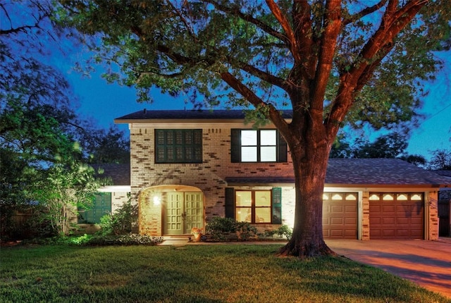 view of front of home with driveway, french doors, a front yard, a garage, and brick siding