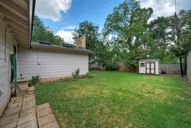 view of yard featuring a storage shed, an outdoor structure, and a fenced backyard