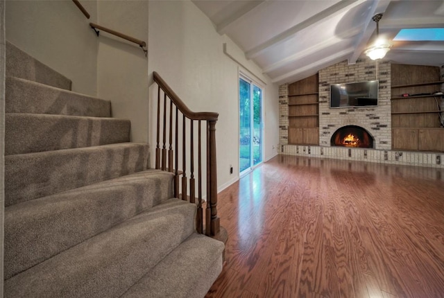unfurnished living room with stairs, built in features, wood finished floors, ceiling fan, and lofted ceiling with beams