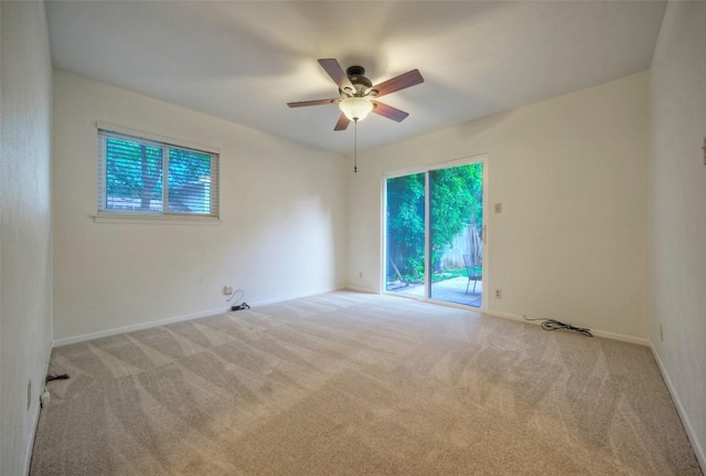 carpeted empty room featuring a ceiling fan, baseboards, and a healthy amount of sunlight
