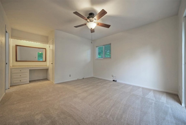 unfurnished bedroom featuring baseboards, light carpet, and ceiling fan
