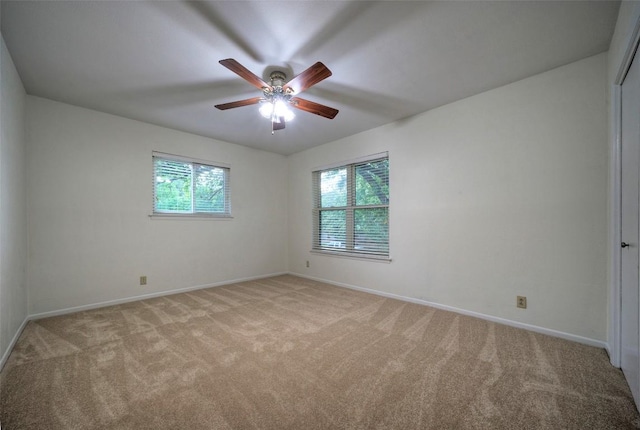 unfurnished room with baseboards, light carpet, and a wealth of natural light