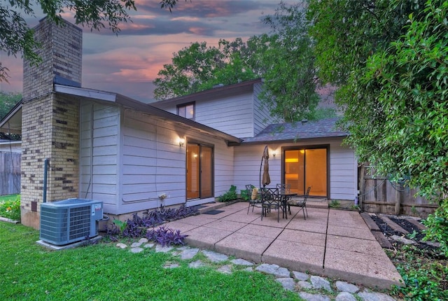 back of house featuring fence, central air condition unit, a chimney, and a patio area
