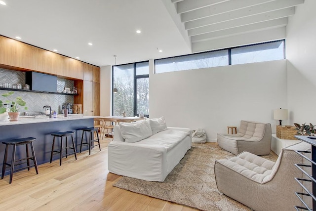 living area with bar, recessed lighting, plenty of natural light, and light wood-type flooring