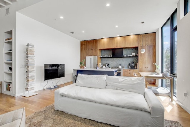 living area with light wood-style floors, baseboards, recessed lighting, and visible vents