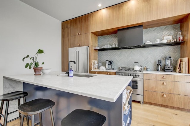 kitchen featuring a breakfast bar area, high quality appliances, open shelves, and a sink