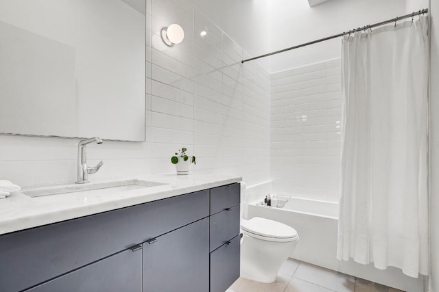 bathroom with tile walls, tile patterned flooring, shower / tub combo, vanity, and toilet