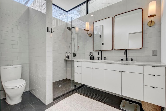 full bathroom with double vanity, a sink, walk in shower, and tile patterned floors
