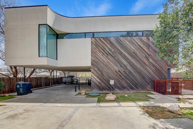 view of side of property featuring fence and a carport