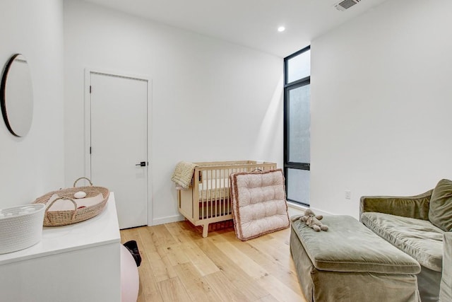 living area featuring recessed lighting, light wood finished floors, and visible vents