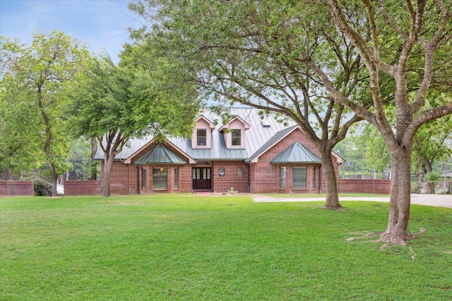 640 Woodlake Dr, Mcqueeney, TX 78123 - tudor home featuring a standing seam roof, metal roof, a front yard, brick siding, and fence