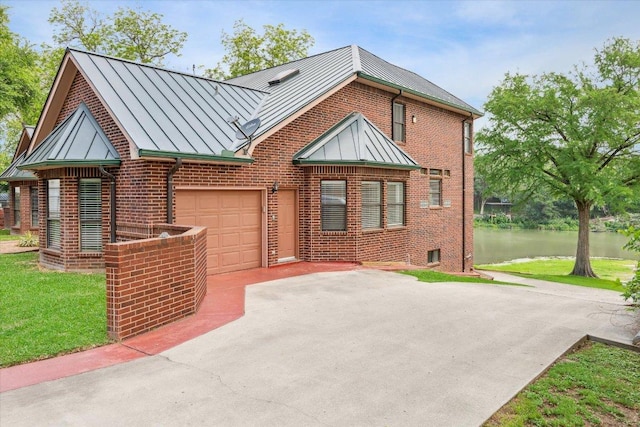 640 Woodlake Dr, Mcqueeney, TX 78123 - view of front of property with a standing seam roof, brick siding, concrete driveway, an attached garage, and a water view