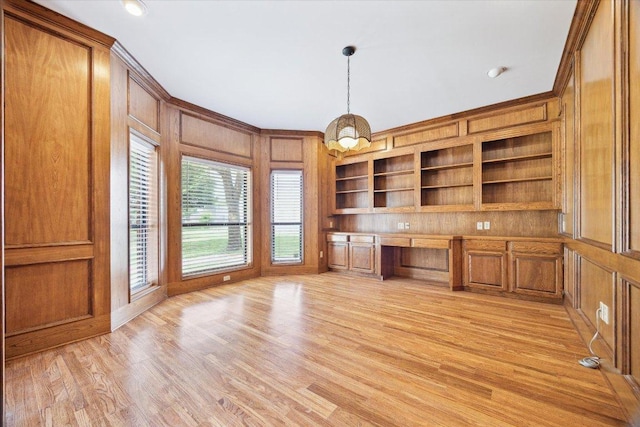 640 Woodlake Dr, Mcqueeney, TX 78123 - unfurnished office featuring crown molding, built in features, built in study area, wooden walls, and light wood-style floors