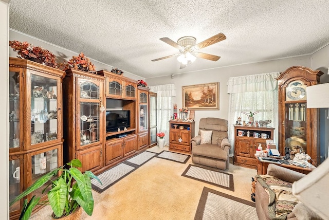 living area featuring a textured ceiling, ceiling fan, a wealth of natural light, and light carpet