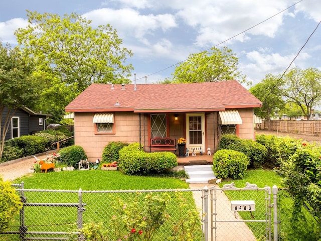 view of front of house featuring a porch, a gate, a front lawn, and a fenced front yard