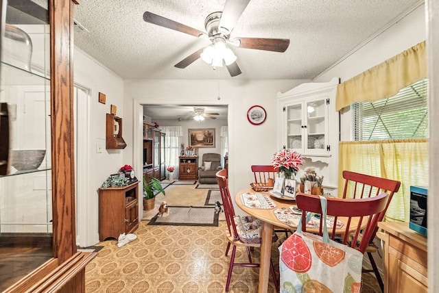 dining space with a ceiling fan and a textured ceiling