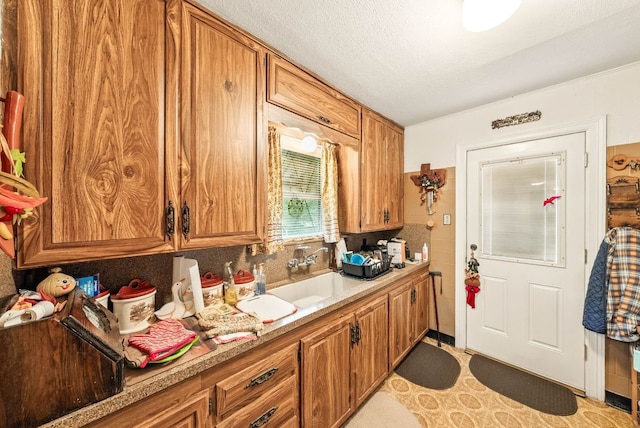 kitchen with brown cabinets, a sink, and light countertops