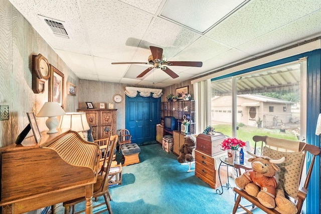 sitting room featuring carpet flooring, ceiling fan, visible vents, and a paneled ceiling