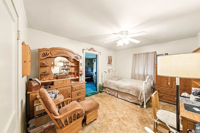 bedroom with light colored carpet, crown molding, and ceiling fan