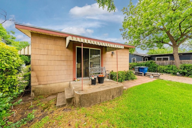 rear view of property with a lawn and fence