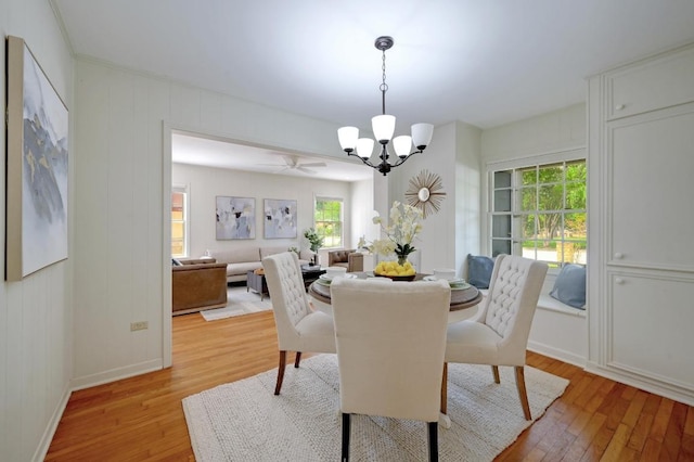 dining room featuring a chandelier, light wood-type flooring, healthy amount of natural light, and baseboards