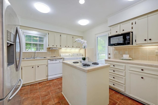 kitchen with white appliances, a sink, separate washer and dryer, tile counters, and backsplash