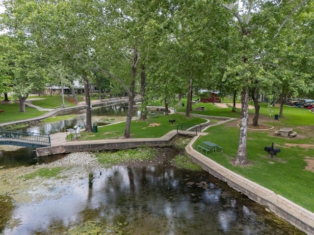 view of community featuring a lawn, a water view, and a boat dock