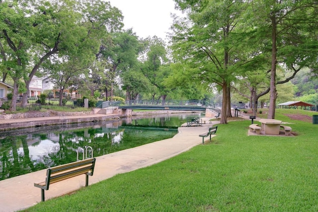 view of community with a lawn and a water view