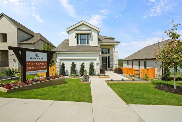view of front facade with stucco siding, driveway, a front yard, and fence