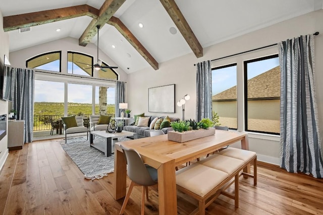dining room featuring a ceiling fan, light wood-style flooring, beam ceiling, and high vaulted ceiling