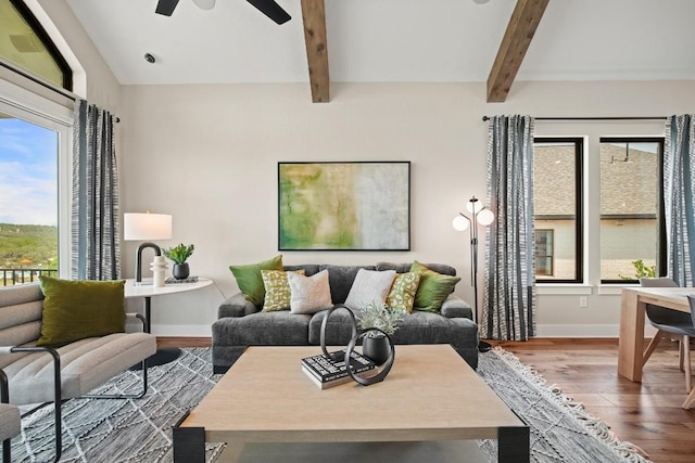 living room featuring baseboards, ceiling fan, wood finished floors, and beamed ceiling
