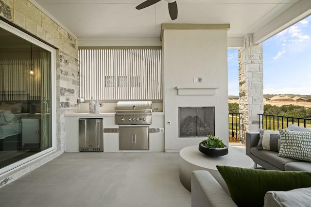 view of patio with an outdoor living space, a ceiling fan, exterior kitchen, and grilling area