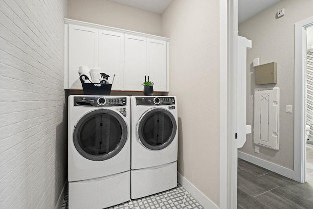 clothes washing area with washer and dryer, baseboards, and cabinet space