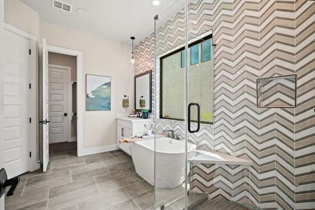 bathroom with an accent wall, wallpapered walls, baseboards, a shower stall, and visible vents