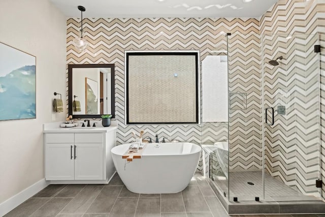 bathroom featuring wallpapered walls, a shower stall, baseboards, and an accent wall