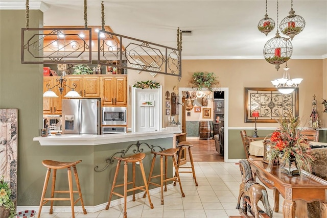 kitchen featuring appliances with stainless steel finishes, light countertops, a kitchen bar, visible vents, and ornamental molding