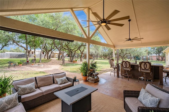 view of patio with fence, a ceiling fan, outdoor dry bar, and an outdoor living space with a fire pit