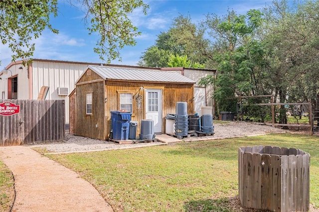 view of outbuilding featuring fence and an outdoor structure