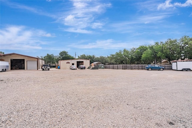 view of yard featuring fence, an outbuilding, and a detached garage