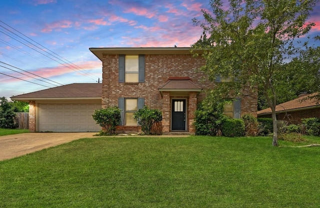 view of front of house featuring a lawn, brick siding, an attached garage, and concrete driveway