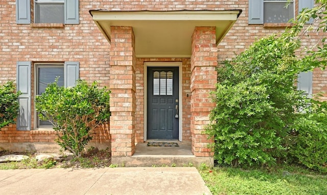 entrance to property featuring brick siding