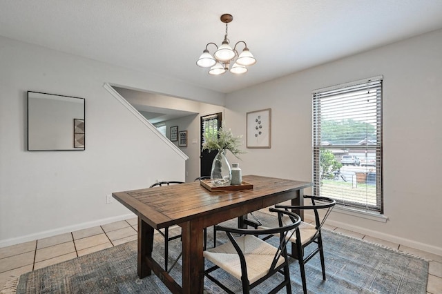 dining room featuring light tile patterned floors, baseboards, and a chandelier