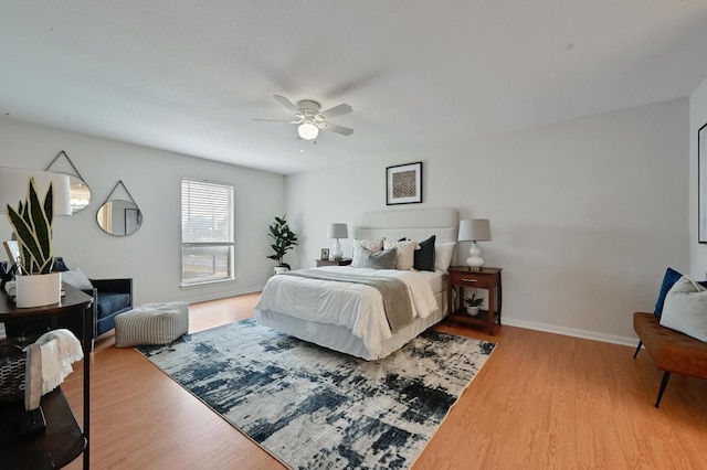 bedroom with baseboards, ceiling fan, and wood finished floors