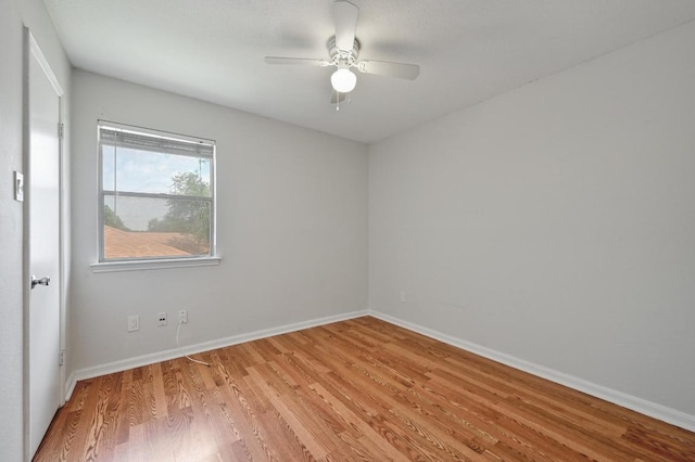 spare room with a ceiling fan, baseboards, and light wood finished floors