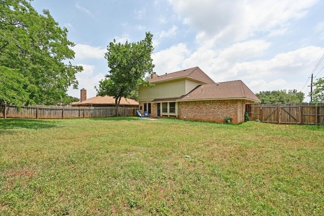 view of yard featuring a fenced backyard and a gate