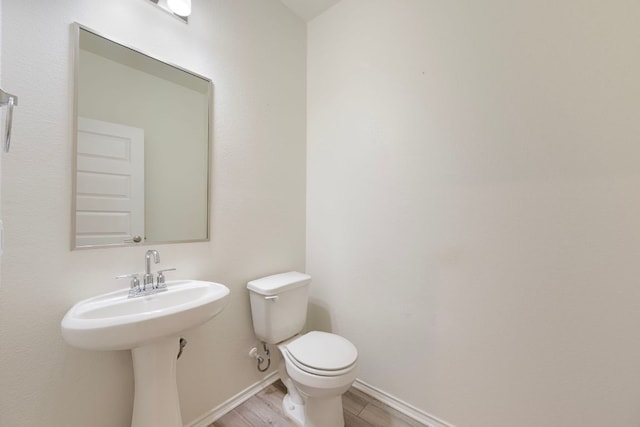 3944 Tufino Ln, Round Rock, TX 78665 - bathroom featuring toilet, baseboards, and wood finished floors