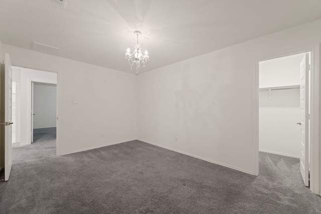 3944 Tufino Ln, Round Rock, TX 78665 - unfurnished bedroom with baseboards, visible vents, carpet floors, a walk in closet, and a notable chandelier