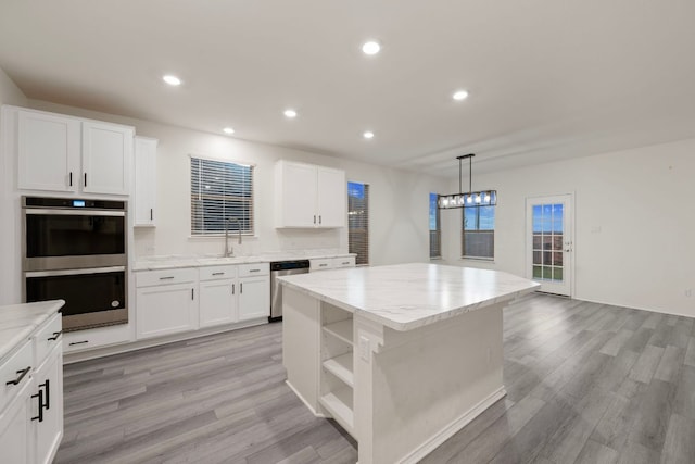 3944 Tufino Ln, Round Rock, TX 78665 - kitchen featuring open shelves, a center island, light wood-style floors, and stainless steel appliances