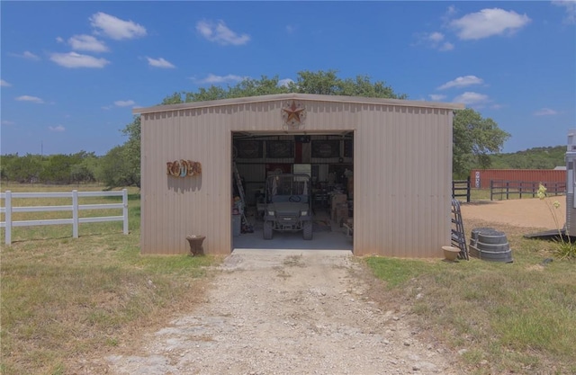 view of pole building with fence and driveway
