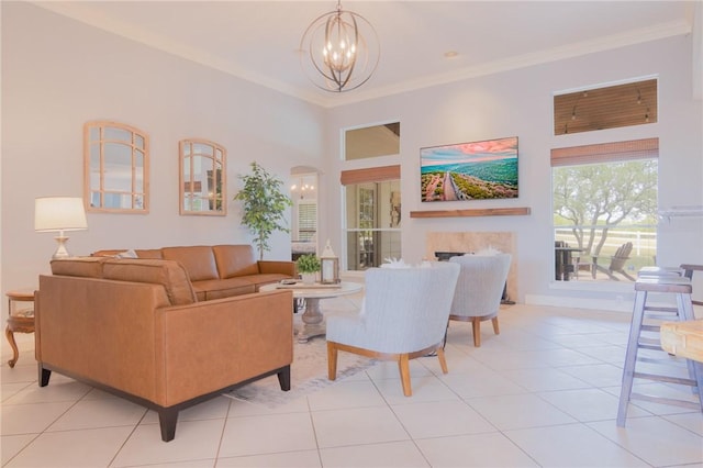 living area featuring an inviting chandelier, ornamental molding, light tile patterned flooring, and a fireplace